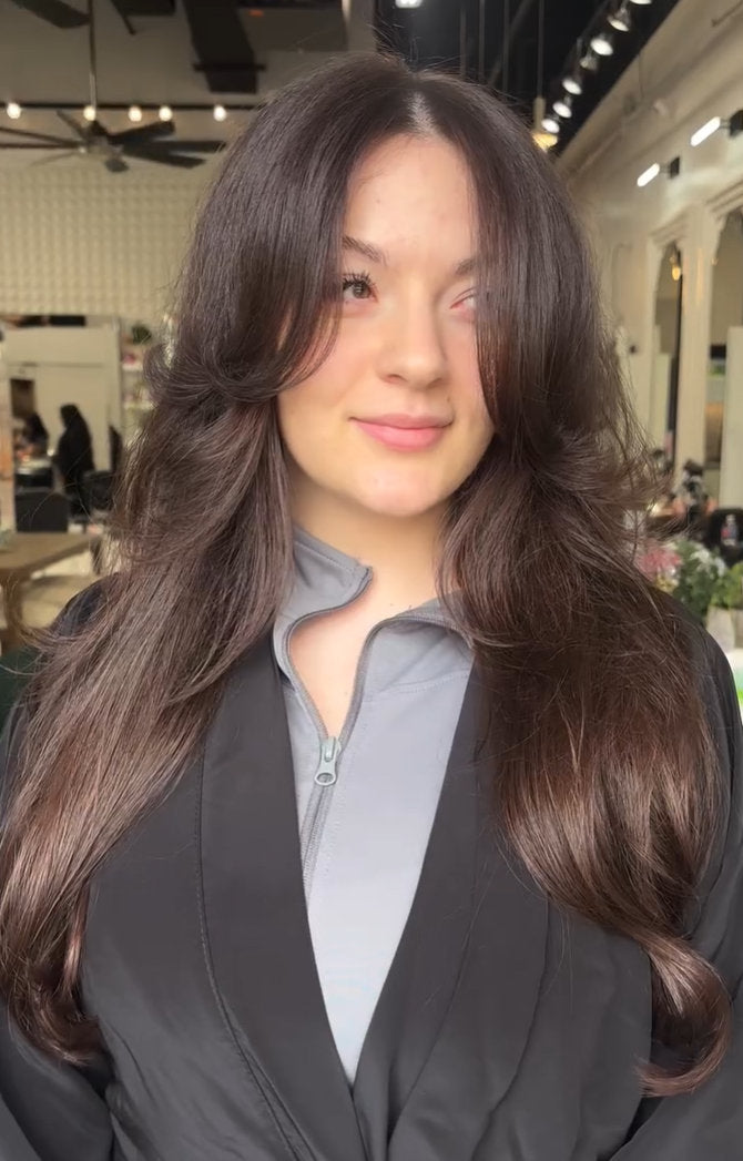 Layered women's haircut with curtain bangs at Hello Beautiful Signature Salon, Missouri City TX