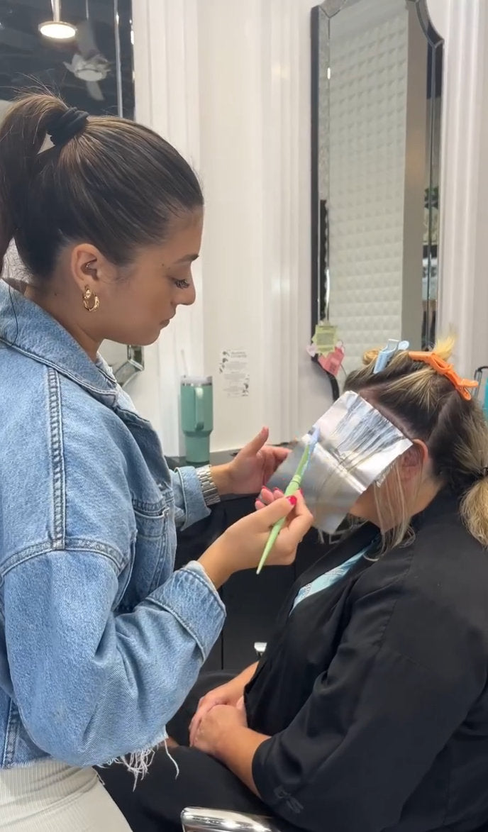 Stylist placing foil highlights at Hello Beautiful Signature Salon, Missouri City TX